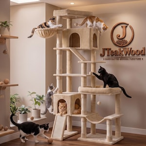 May include: A multi-level beige carpeted cat tree with multiple platforms, a hammock, two enclosed cubbies, and a ramp. Several cats are interacting with the structure. On the wall, a wooden logo reads JTeakWood Handcrafted Wooden Furniture.