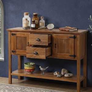 May include: A wooden sideboard featuring two side cabinets with black metal hinges, two stacked central drawers with dark metal pulls, and an open bottom shelf. The top surface holds glass apothecary jars, a magnifying glass, and a notebook.