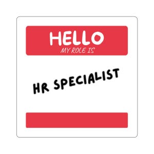 May include: A square sticker with a white background and two horizontal red bars. The top bar features the white text HELLO MY ROLE IS. The center of the sticker displays the black text HR SPECIALIST in a bold, rounded, sans-serif font style.