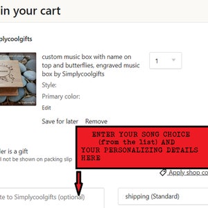 Pu&ograve; includere: Una scatola di musica in legno con un design a farfalla e il nome "Emma" inciso sul coperchio. La scatola &egrave; mostrata su un letto di piccole pietre rotonde. Il testo "ENTER YOUR SONG CHOICE (from the list) AND YOUR PERSONALIZING DETAILS HERE" &egrave; visualizzato in rosso.