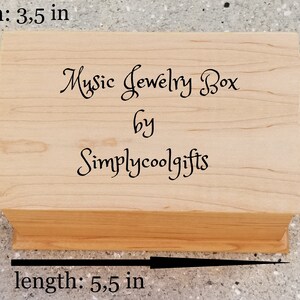 Puede incluir: Una caja de m&uacute;sica de madera para joyas con el texto "Music Jewelry Box by Simplycoolgifts" en la tapa. La caja mide 14 cm de largo, 9 cm de ancho y 6,5 cm de alto.