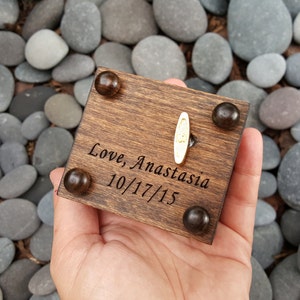 Pu&ograve; includere: Una scatola musicale in legno con una manovella dorata e un'iscrizione personalizzata che recita "Love, Anastasia 10/17/15".