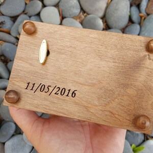 Puede incluir: Una caja de m&uacute;sica de madera con una llave de cuerda de lat&oacute;n y una fecha grabada en la parte superior: 11/05/2016.