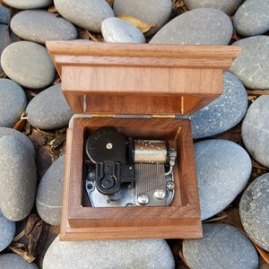 music box with open lid showing musical movement inside