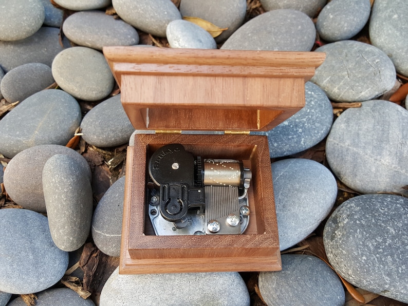 music box with open lid showing musical movement inside