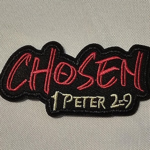 May include: A black embroidered patch with a red stitched outline and the word CHOSEN in red capital letters. Below the word CHOSEN, the text 1 PETER 2:9 is stitched in a light yellow thread. The patch has a black background and a black border.