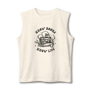 May include: A cream-colored sleeveless shirt featuring a black graphic print of a stack of books topped with a human skull, surrounded by floral elements and stars, with the text "KNOW BOOKS" above and "KNOW LIFE" below the central illustration.