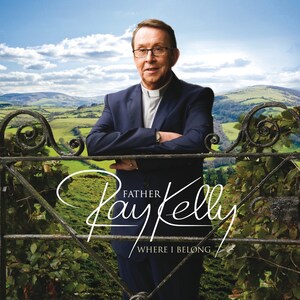 May include: A man wearing a suit and clerical collar stands in front of a wrought iron gate. The gate is open and behind it is a green field with rolling hills. The man's name is Father Ray Kelly and the text "Where I Belong" is written below his name.
