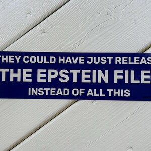 Puede incluir: Una pegatina rectangular con fondo azul oscuro y texto en blanco que dice: THEY COULD HAVE JUST RELEASED THE EPSTEIN FILES INSTEAD OF ALL THIS. La pegatina tiene un acabado liso y brillante y está orientada horizontalmente.