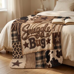 May include: A plush throw blanket featuring a patchwork design with brown, tan, and black patterns including cow print, leopard print, and plaid. The center displays the text Snuggle Bug in a rope-style font, accented by brown stars and rope motifs.