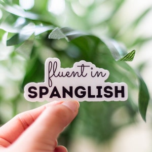 May include: White sticker with black text that reads "fluent in Spanglish".