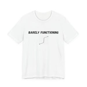 Puede incluir: Una camiseta blanca de manga corta con el texto negro BARELY FUNCTIONING impreso sobre un pequeño gráfico de líneas negro sobre un fondo de cuadrícula claro. El gráfico está centrado en el pecho de la camiseta, que tiene cuello redondo.