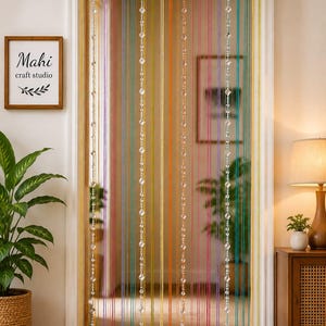 Peut inclure: Un rideau de fils multicolores composé de brins verticaux dans des tons jaune, orange, rose, violet et bleu sarcelle. Le rideau comprend des perles de cristal transparentes en forme de losange suspendues à une tringle en métal.