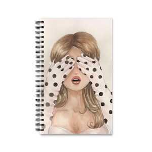Peut inclure: Un carnet à spirales présentant une illustration à l'aquarelle d'une personne aux longs cheveux bruns. La personne se couvre les yeux avec des mains portant des gants blancs ornés de pois noirs. La personne a un teint de peau clair.