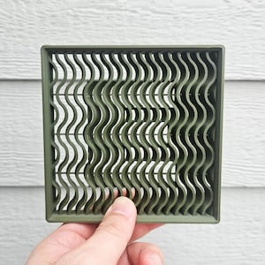 May include: A square olive green grid frame featuring a series of vertical wavy lines that create a textured, repeating pattern throughout the interior. The object is constructed with a solid outer border and thin, consistent wavy dividers.