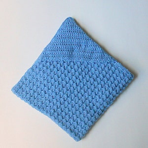 May include: A light blue crocheted baby blanket with a textured pattern.