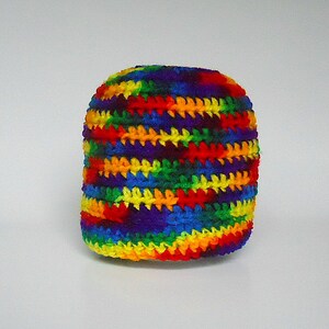 May include: A crocheted hat with a rainbow striped pattern. The hat is made with a variety of colors, including red, orange, yellow, green, blue, indigo, and violet.