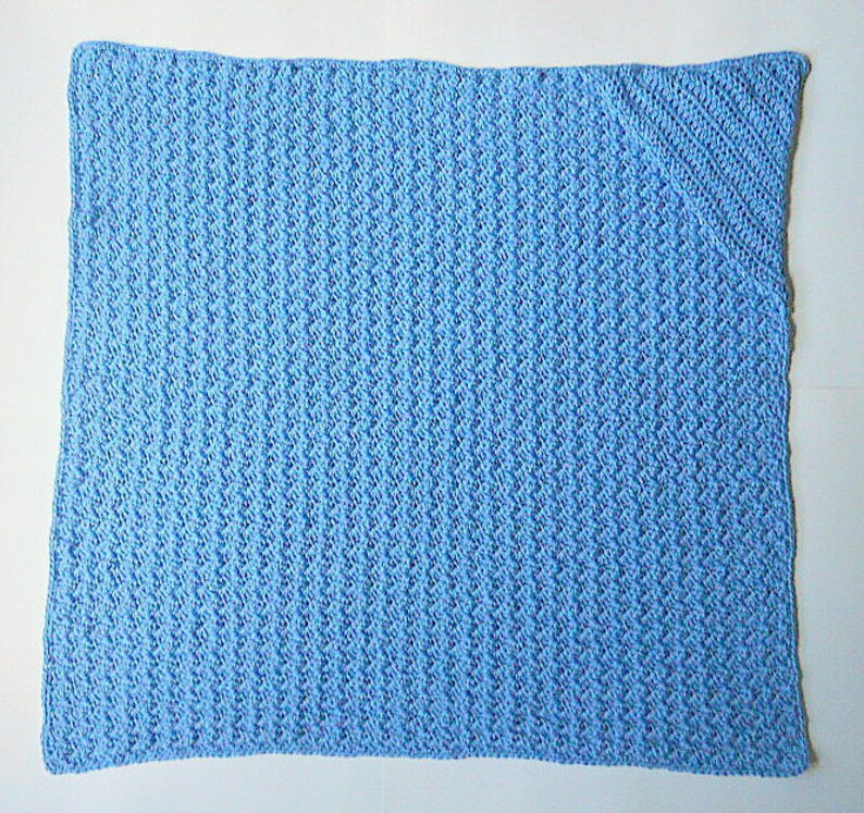 May include: A light blue crocheted baby blanket with a textured pattern.