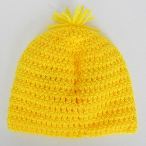 May include: A bright yellow crocheted beanie with a fluffy pom-pom on top.