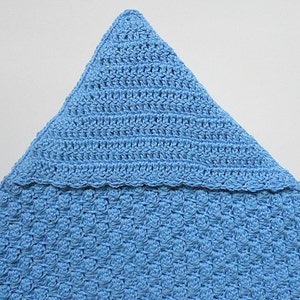 May include: A light blue crocheted baby blanket with a pointed hood. The blanket is made with a textured stitch and has a scalloped edge.