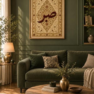 May include: A rectangular framed wall art piece featuring a cream-colored background with intricate floral patterns in gold and brown, centered with the dark red Arabic calligraphy for Sabr, displayed in a wooden frame on a green wall.
