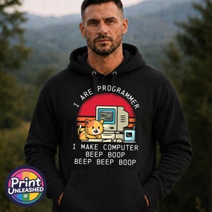 May include: A black hooded sweatshirt featuring a graphic of a cat sitting next to a vintage computer. The text reads I ARE PROGRAMMER I MAKE COMPUTER BEEP BOOP BEEP BEEP BOOP. The design includes a red sun background and a small blue icon.