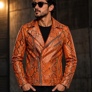 May include: A vibrant orange and black snakeskin-patterned leather motorcycle jacket featuring a wide notched lapel, an asymmetrical silver-tone metal zipper closure, zippered side pockets, zippered sleeve cuffs, and a buckled waist belt.