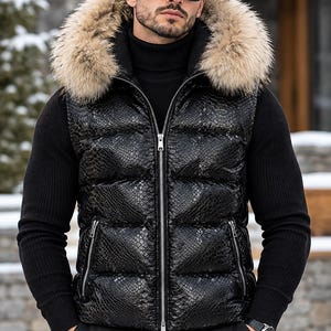 May include: A black puffer vest featuring a snakeskin-textured finish, a full-length silver front zipper, and a hood trimmed with thick, light brown faux fur. The vest is worn over a black ribbed turtleneck sweater with long sleeves.