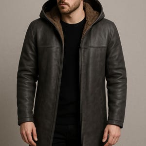 May include: A dark charcoal gray hooded coat featuring a full-length front zipper, long sleeves, and a brown faux fur lining. The coat has a smooth exterior finish and a structured hood. The logo PlanioPelle is visible in the top left corner.