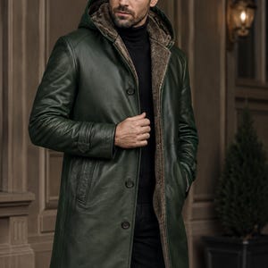 May include: A dark green leather coat featuring a hood, a brown faux fur lining, and a front button closure. The coat has long sleeves with cuff details and side pockets. The PlanioPelle logo is visible in the upper left corner of the image.
