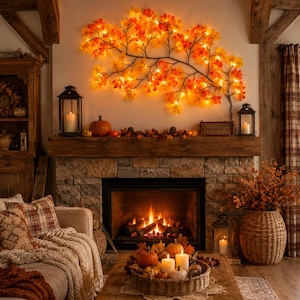 May include: A wall-mounted light fixture shaped like a sprawling tree branch with illuminated orange, yellow, and red maple leaves. The branch is dark brown and features numerous small, warm-toned LED lights tucked behind the fabric leaves.