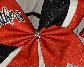 Laço de líder de torcida Panthers laranja escuro com glitter: centro prateado (18 cm) em vinil sublimado.