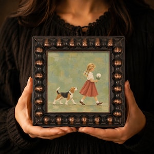 May include: A square framed painting featuring a young child with blonde braided hair wearing a white shirt and a red skirt, walking while holding a white flower. A beagle dog walks alongside the child on a muted green background.