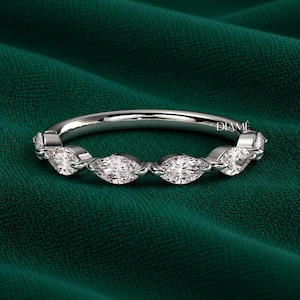 May include: A silver-toned band ring featuring a series of marquise-cut clear stones set along the top half. The metal has a polished finish, and the word DIAME is engraved in small, clear lettering on the inner surface of the ring band.