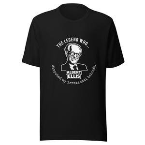 May include: A black short-sleeved t-shirt featuring a white graphic print of Albert Ellis. The text reads: THE LEGEND WHO... ALBERT ELLIS disputed my irrational beliefs. The design is centred on the chest of the shirt, showcasing a portrait.
