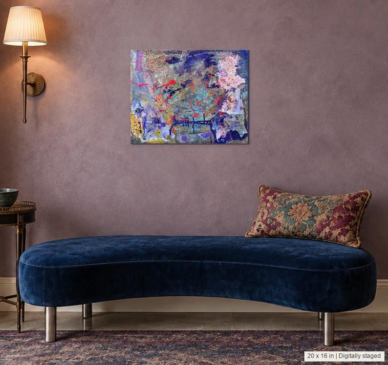 May include: A rectangular canvas painting featuring an abstract composition of layered blue, purple, pink, and yellow paint splatters and marks. The artwork is displayed on a wall above a curved navy blue velvet bench with a patterned throw pillow.