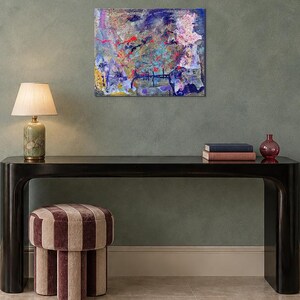 May include: A rectangular canvas wall art piece measuring 20 by 16 inches, featuring an abstract composition with layered textures and vibrant splashes of blue, purple, pink, yellow, and red paint across the surface in a chaotic, expressive style.