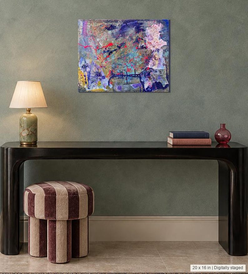 May include: A rectangular canvas wall art piece measuring 20 by 16 inches, featuring an abstract composition with layered textures and vibrant splashes of blue, purple, pink, yellow, and red paint across the surface in a chaotic, expressive style.