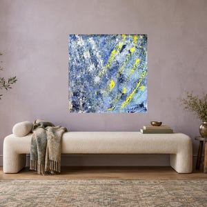 May include: A square canvas painting featuring an abstract composition of layered blue, white, and dark navy paint strokes with prominent, bright yellow vertical and diagonal accents applied in a textured, expressive, and thick impasto style.