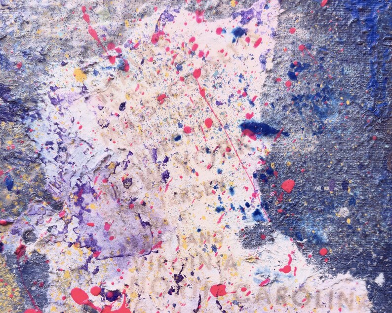 May include: An abstract painting featuring a textured surface with layers of blue, white, and purple paint. Splatters of bright pink, yellow, and dark blue cover the canvas. Faint text is visible, including the words New York, New Jersey, and North Carolina.