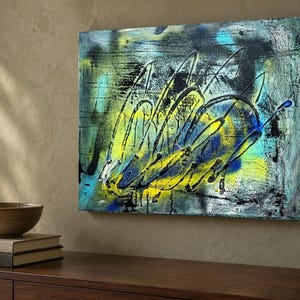 May include: A rectangular canvas painting featuring abstract layers of vibrant yellow, electric blue, and deep black paint. The composition displays energetic, sweeping brushstrokes and splattered textures that create a sense of movement across the surface.