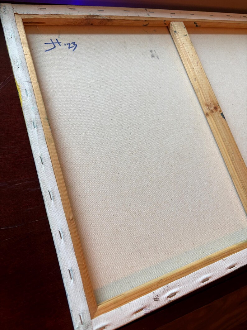 Pu&ograve; includere: Il retro di una tela rettangolare tesa su un telaio in legno chiaro. La tela &egrave; fissata con punti metallici lungo i bordi. Un segno blu scritto a mano che riporta H '23 &egrave; visibile nell'angolo in alto a sinistra del tessuto della tela.