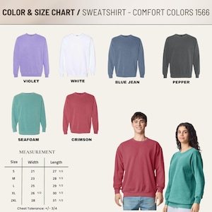 May include: A color and size chart for Comfort Colors 1566 sweatshirts. It displays six crewneck sweatshirts in violet, white, blue jean, pepper, seafoam, and crimson. A measurement table lists widths and lengths in inches for sizes S to 2XL.
