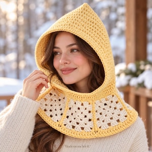 May include: A yellow crochet hood with a pointed top and a base featuring cream-colored granny square motifs. The hood is constructed with a textured stitch pattern and includes the text Moderncrochet4U at the bottom center.