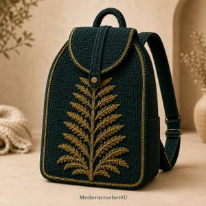 Puede incluir: Una mochila de ganchillo verde oscuro con un bordado de hoja de helecho dorada en la solapa y el cuerpo. La mochila tiene un asa superior, correas ajustables con hebillas metálicas y un cierre de presión dorado. El texto Moderncrochet4U está abajo.