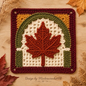May include: A square crochet motif featuring a central dark orange maple leaf applique. The leaf is framed by an off-white lattice pattern, an olive green arch, and a deep burgundy border. The text Design by Moderncrochet4U is visible below.