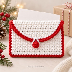 May include: A white crocheted envelope-style pouch with a red border and a central red button closure. A blank white rectangular card is tucked inside the pouch. The text "Design by Moderncrochet4U" is printed at the bottom of the image.