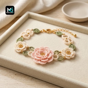 May include: A crochet bracelet featuring a large central pink flower, two smaller cream-colored flowers, and green leaves. The floral elements are accented with small gold beads and connected by a gold-tone metal chain with a lobster clasp closure.