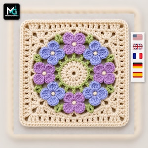 May include: A square crochet motif featuring a cream-colored border and a central circular design. The center is surrounded by eight alternating purple and light blue four-petaled flowers with small green leaves, all worked in yarn.