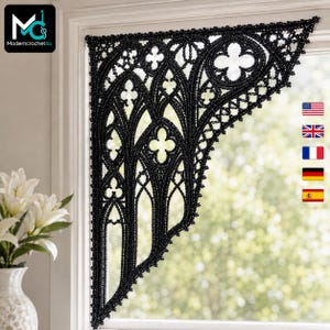 Puede incluir: Una cenefa de ventana tejida a ganchillo en color negro con un intrincado patrón de arcos góticos, arcos apuntados y motivos de cuatrifolio. La pieza textil está montada en la esquina superior de un marco de ventana con encaje calado.